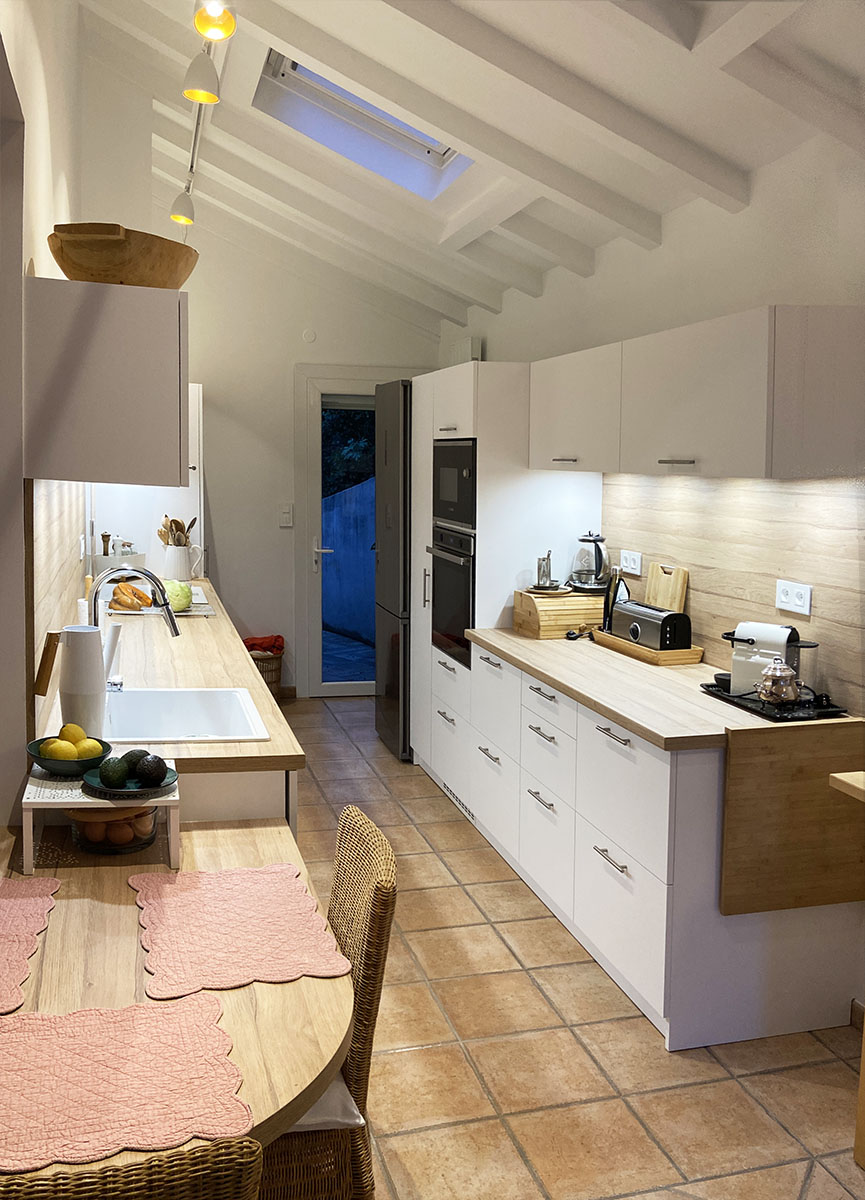 Façades — Blanc alpin.
Plan de travail et crédence — Décor chêne.
Evier — Fragranit Franke®.
Électroménager — Plaque de cuisson, hotte, four et frigo.