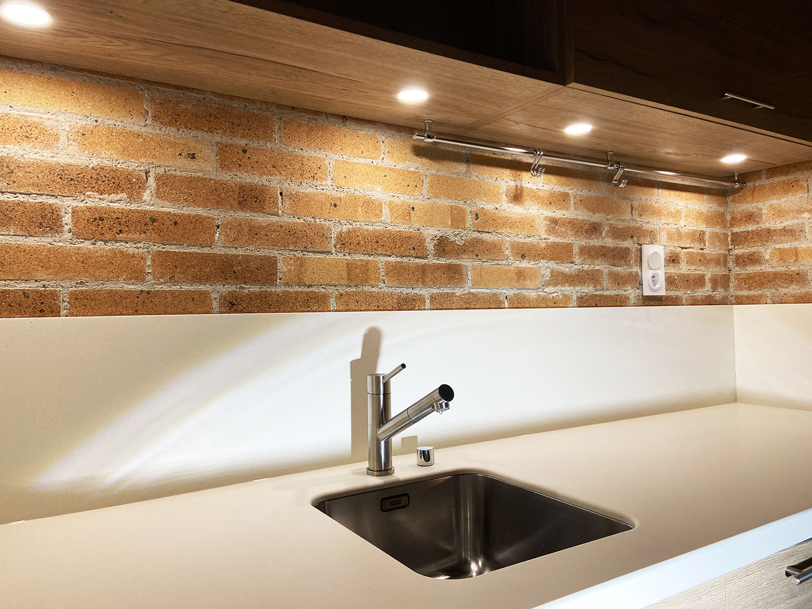 Façades — Décor Chêne, Pores synchonisé et fil Suivi d'une façade à l'autre.
Plan de travail et crédence — Résine V-Korr®.
Evier sous plan — Inox.