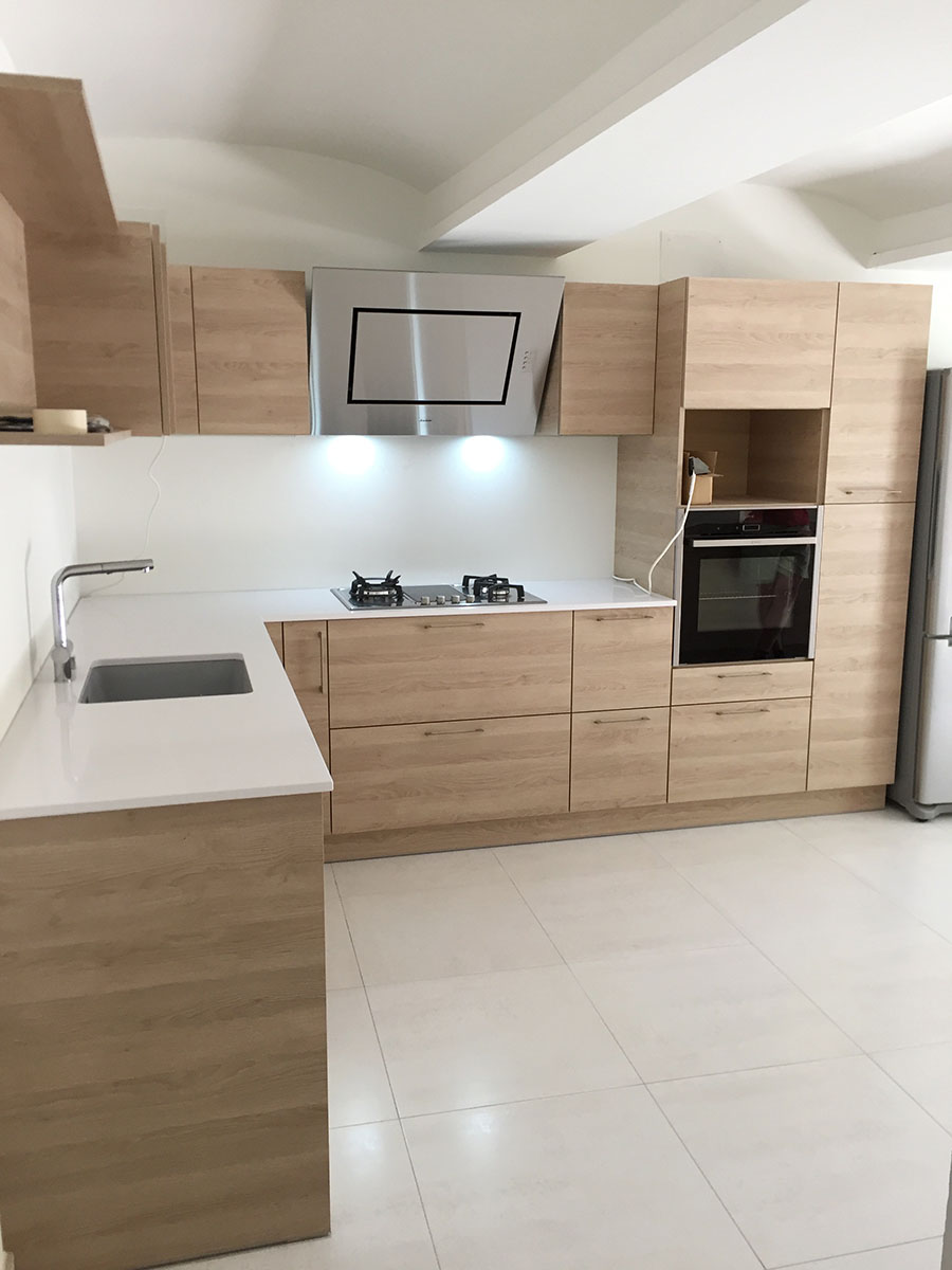 Façade et corps de meuble — Décor chêne Gladstone.
Poignées — Inox brossées.
Plan de travail — Quartz décors blanc pailleté.
Électroménager — Four, micro-onde, frigo, lave-vaisselle, plaque de cuisson, hotte, bassin sous plan fragnranit®, robinet douchette chromé, bloc prise d'angle.