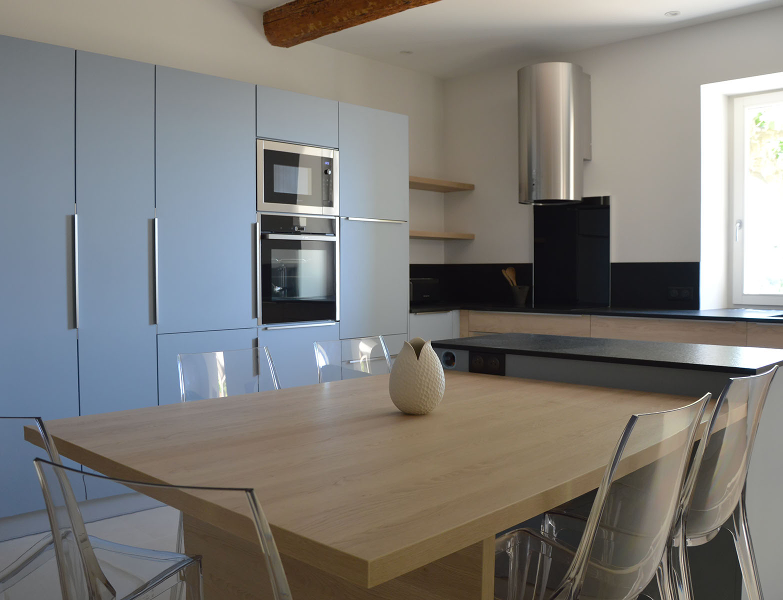 Table ilôt — Décors bleu denim, chêne gladstone.
Façades — Décors bleu denim, chêne gladstone.
Poignées profil — Inox brossé.
Plan de travail et crédence — Granit noir.
Electroménager — Frigo, Four, micro-ondes, lave-vaisselle, plaque de cuisson, hotte.
Crédence de cuisson — Verre trempé noir.
