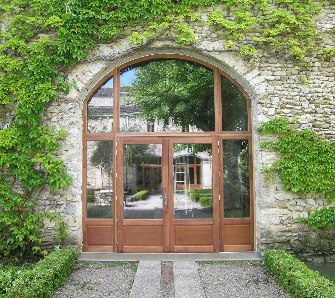 Porte — Bois exotique lasuré.
Vitrage — Cintré sur mesure.