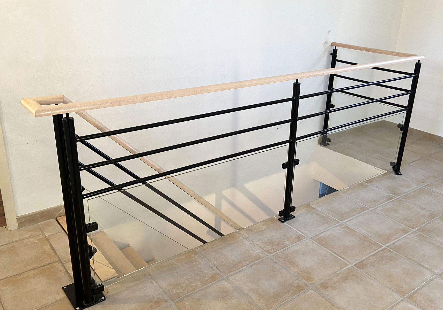 Marches et main courante — Hêtre.
Finition — Verni incolore.
Limon — Métal thermolaqué.
Garde corps — Verre et métal thermolaqué.