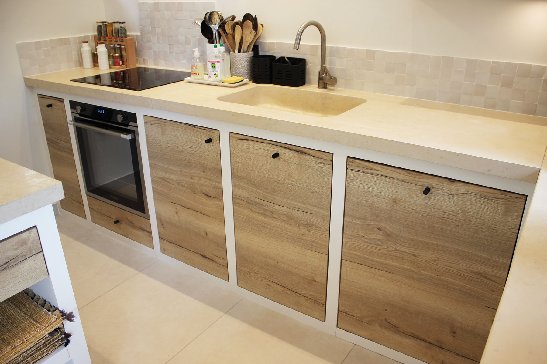 Façades — Décors chêne Halifax natural.
Boutons — Aluminium laqué noir.
Electroménager — Four et plaque de cuisson.